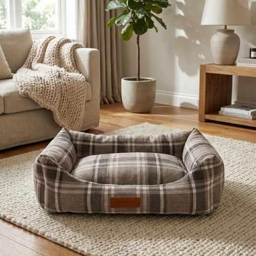Plaid pet bed on textured rug in cozy living room with neutral decor and natural light