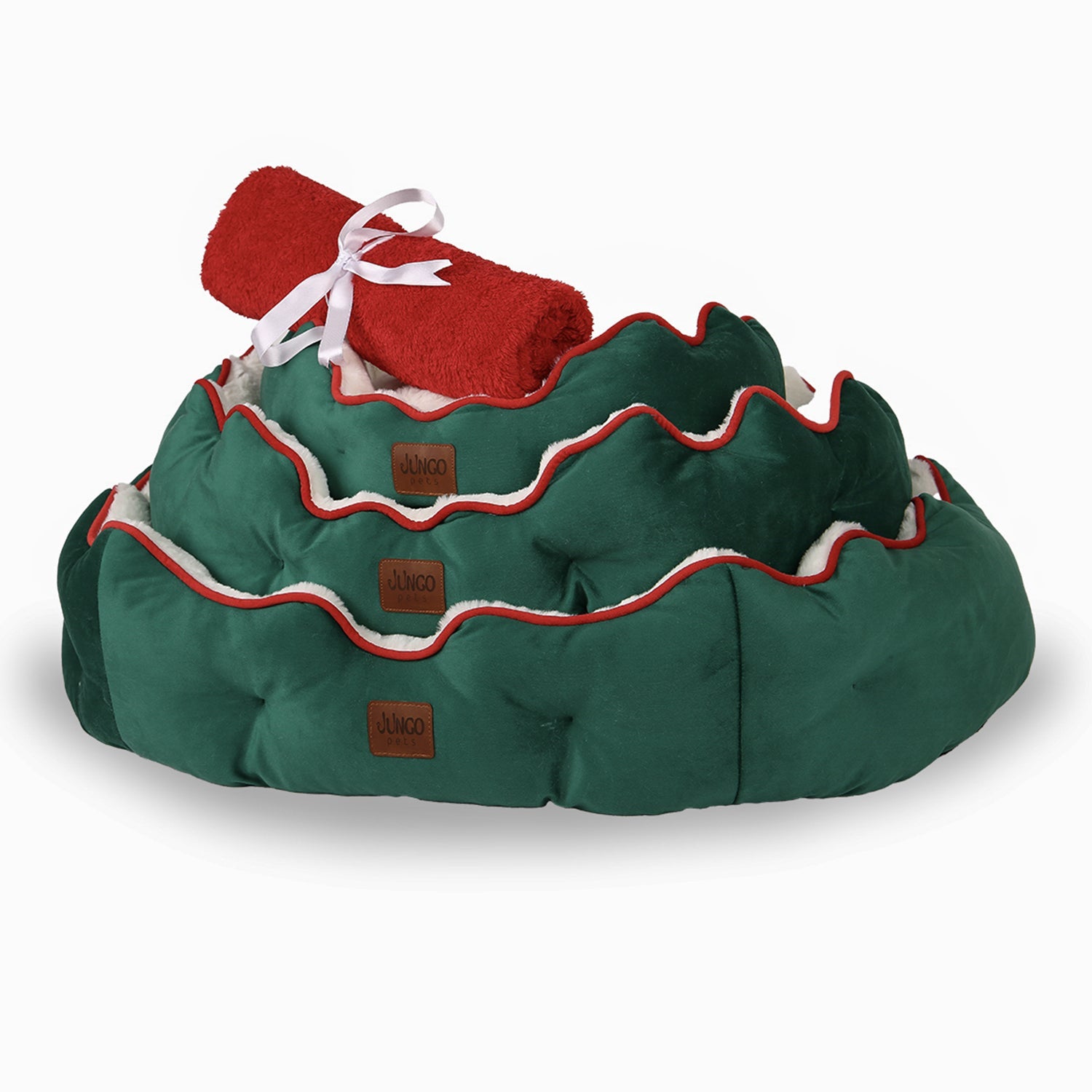 Stacked green Christmas pet beds with red trim and rolled red blanket on top
