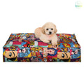 Small fluffy dog on a colorful pop art pet bed against white background