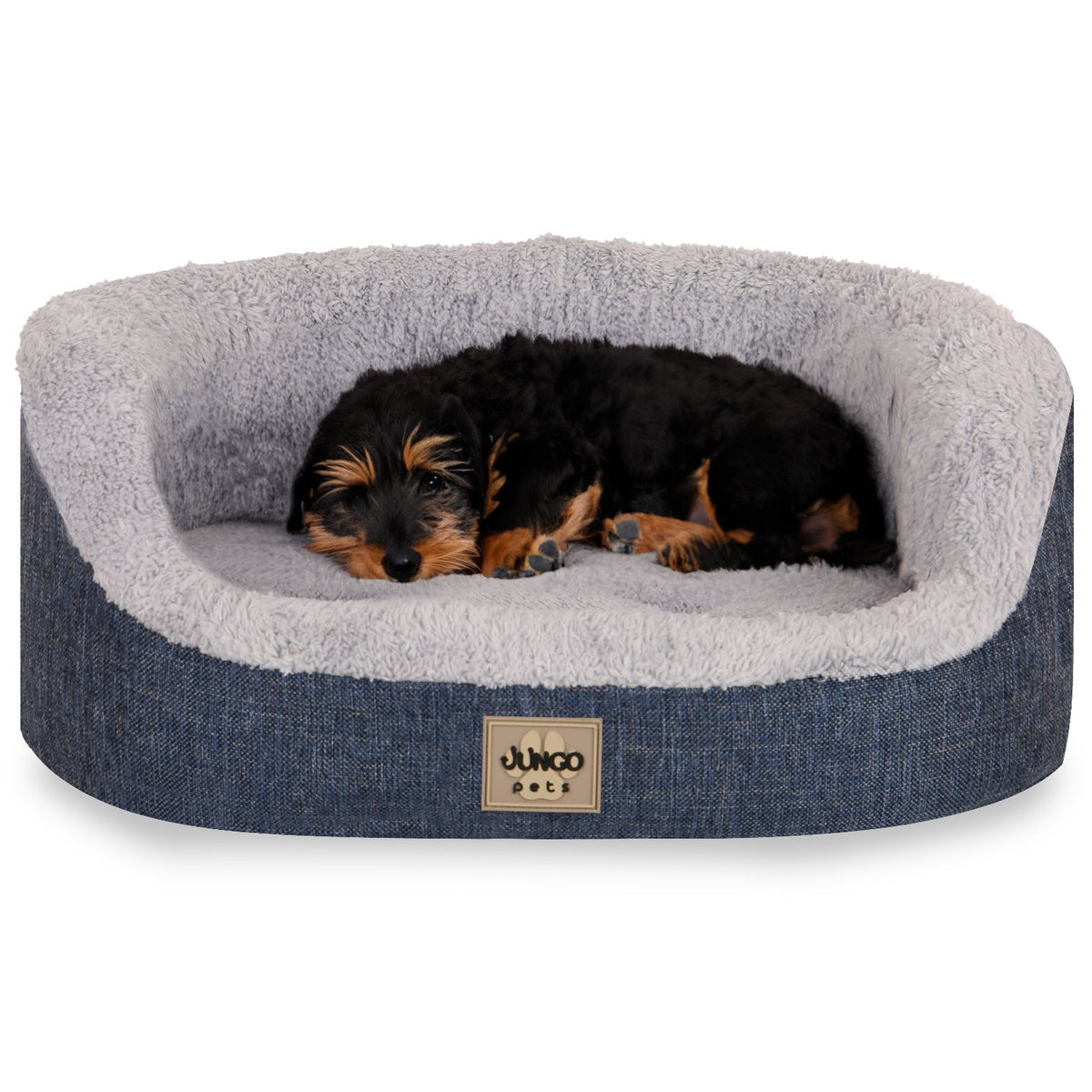 Small dog lying in a blue, plush pet bed with soft gray lining
