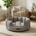 Cozy grey pet bed in modern living room with armchair, rug, and indoor plant