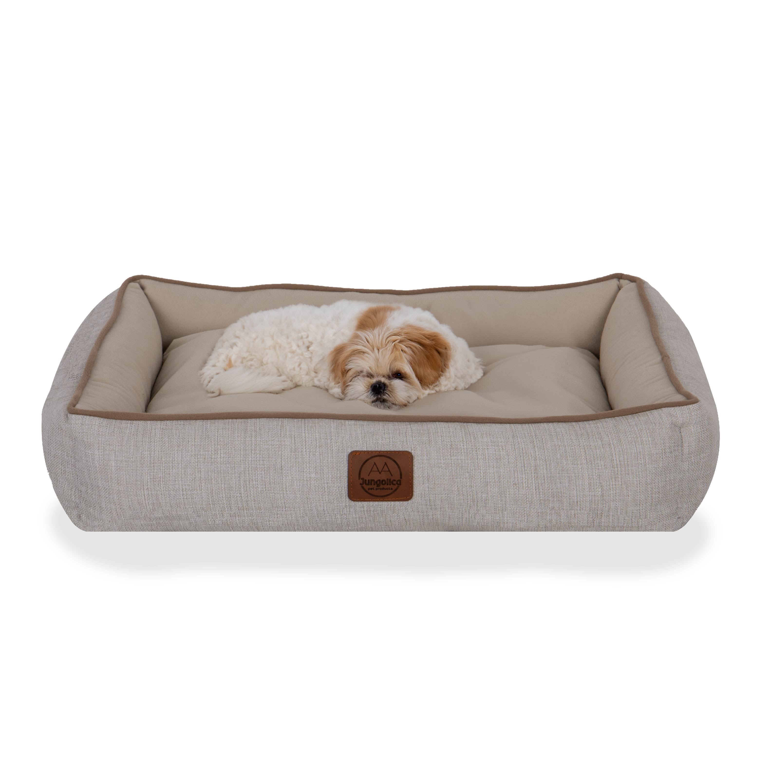 Small dog lying on a beige rectangular pet bed with soft fabric and raised edges