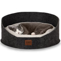 Gray and white cat sleeping in a round dark felt pet bed with soft cushion