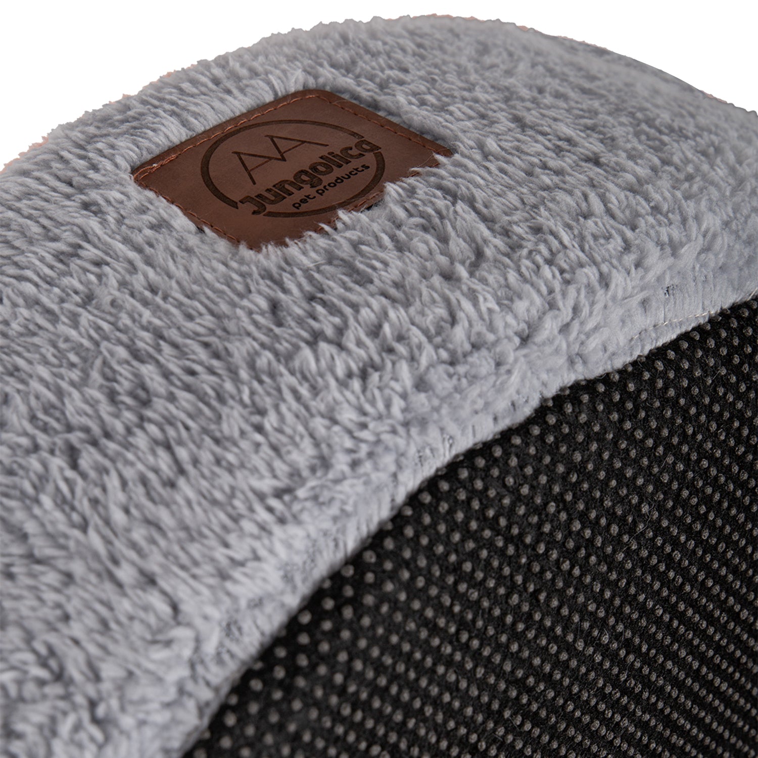 close up of soft light gray cat bed with plush removable cushion and textured black base