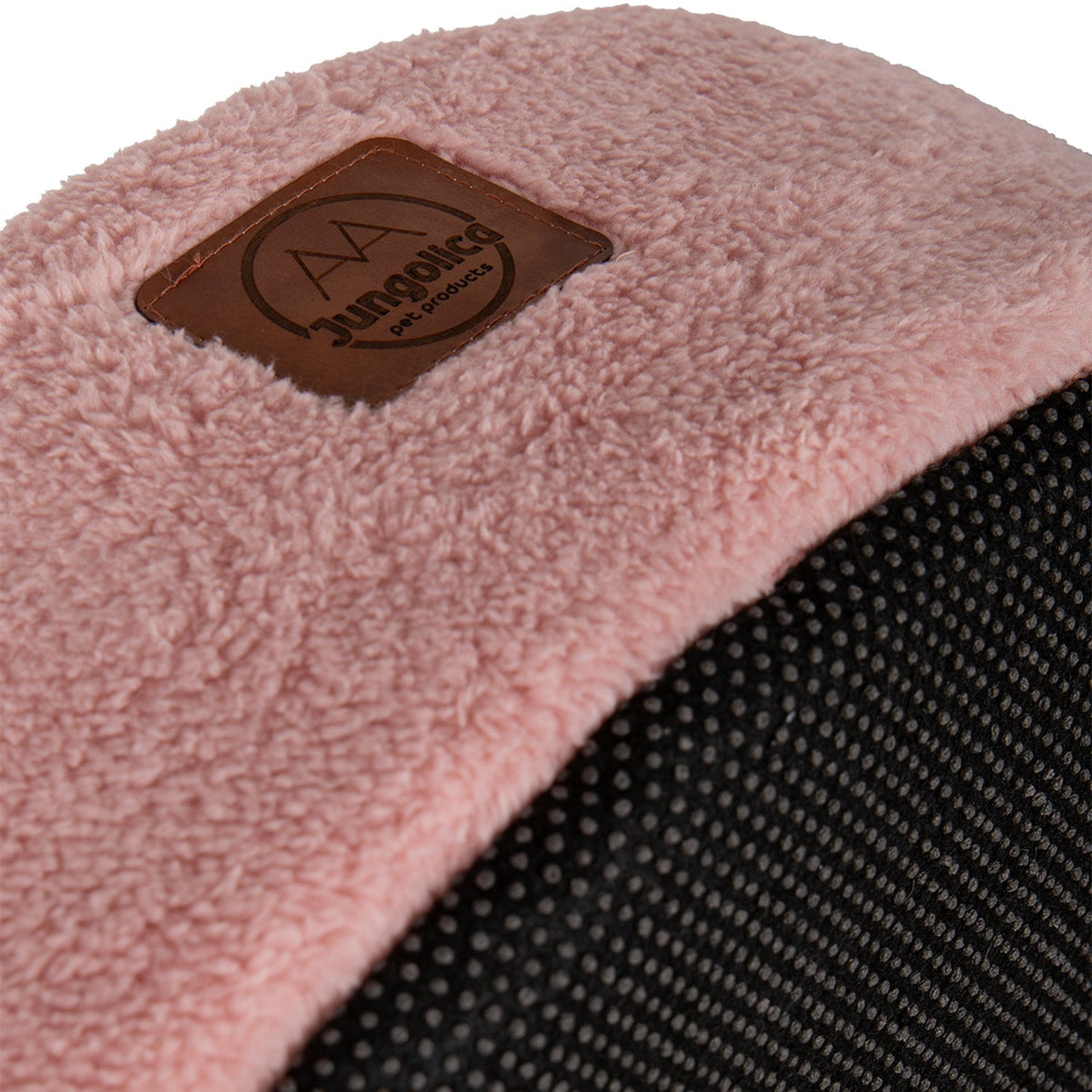 Close-up of pink plush covered cat bed with black textured base