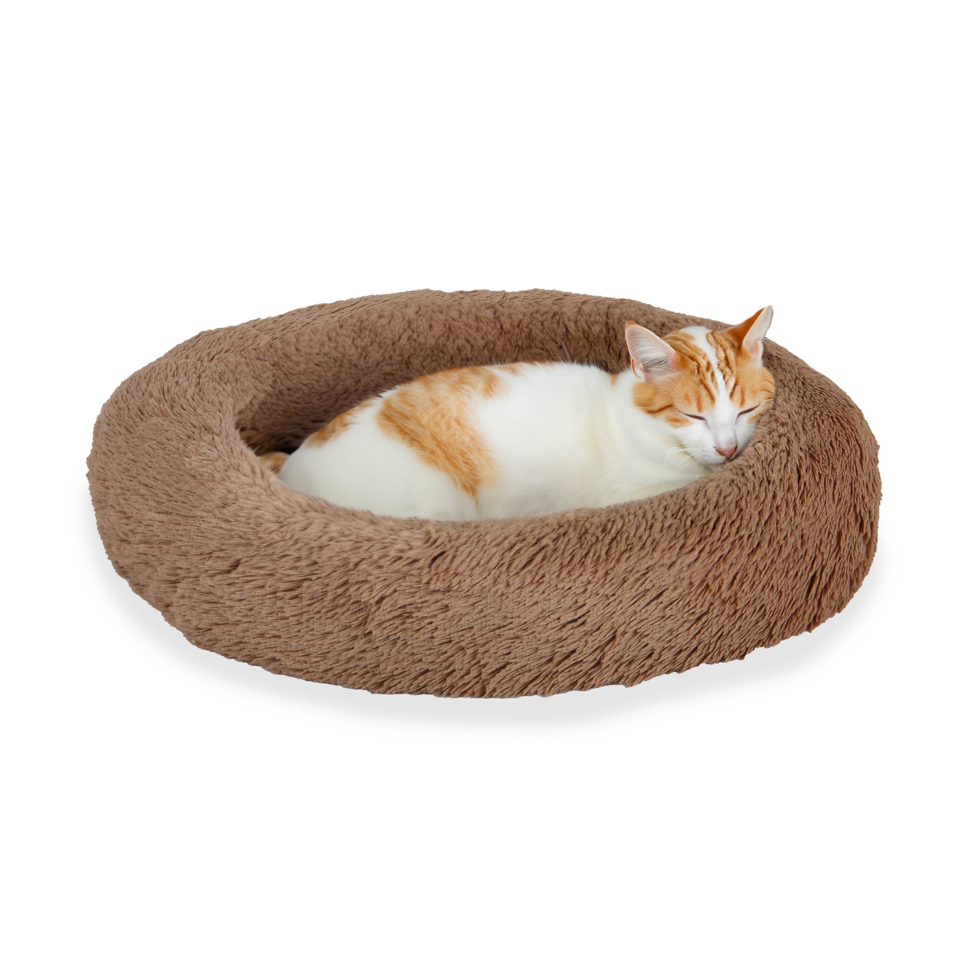 Orange and white cat sleeping on a round, fluffy brown pet bed